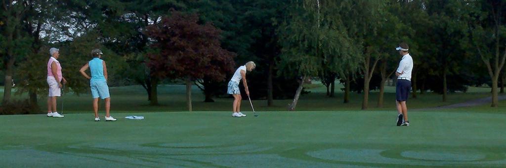  Julie Tabor lines uip a putt on #6 while Tyler Tabor her caddy looks on.&nbsp; Kathy Loviska and Wendy Greenwood her playing partners are watching in the background.